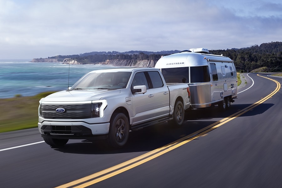 Un Ford F 150 Lightning tire une caravane Airstream sur une autoroute à deux voies
